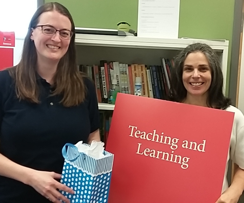 Karen Craigs, winner of the critical thinking and problem solving puzzle, posing with Linda Facchini, Professor in Teaching & Learning, and her prize