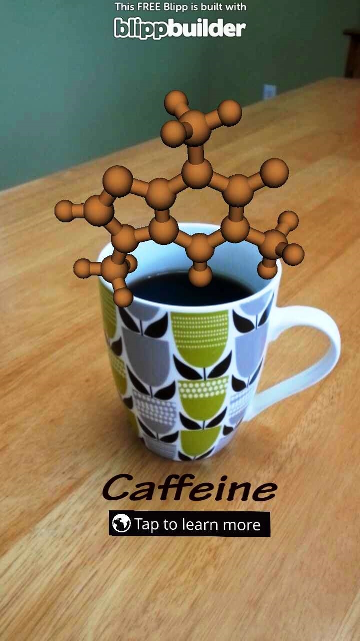 A demonstration of augmented reality showing a cup of coffee and a 3D caffeine molecule.